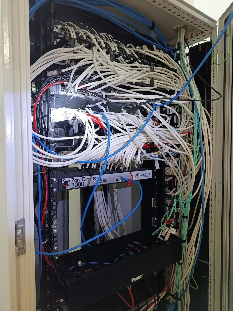 Antes: Patch cords acumulados sin organizadores, cruzando frente a los equipos.