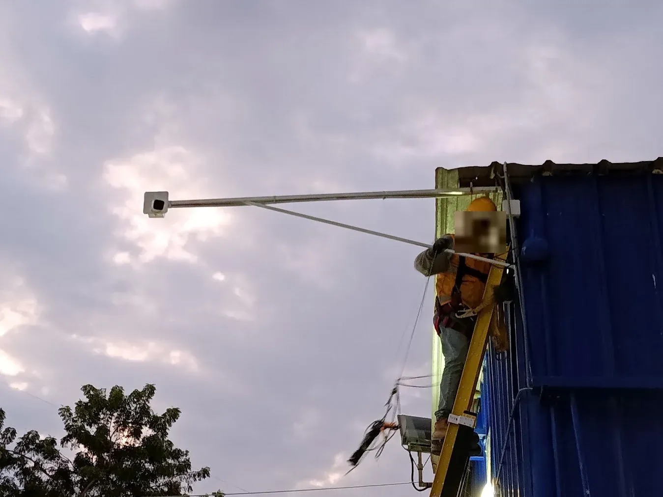 técnico instalando una cámara de seguridad en un brazo de soporte